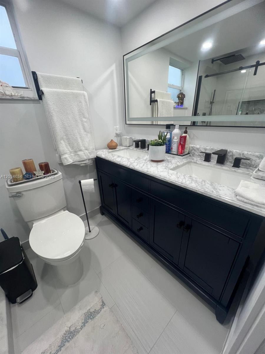9880 Marina Boulevard, Unit 1516 Boca Raton, FL 33428 - Photo 15 of 32 a bathroom with a granite countertop toilet sink and mirror
