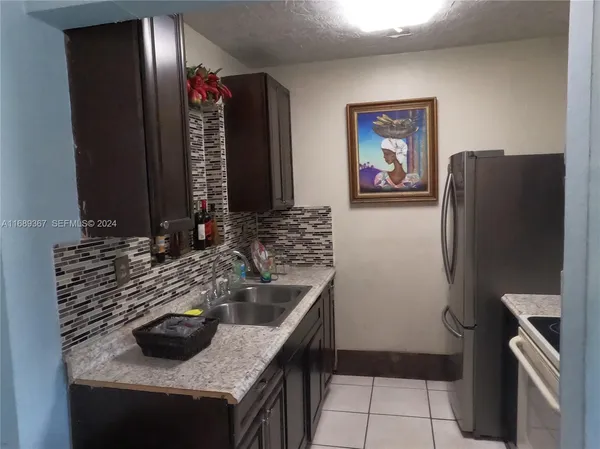 a kitchen with granite countertop a refrigerator and a sink