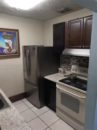 a kitchen with metallic refrigerator and a stove
