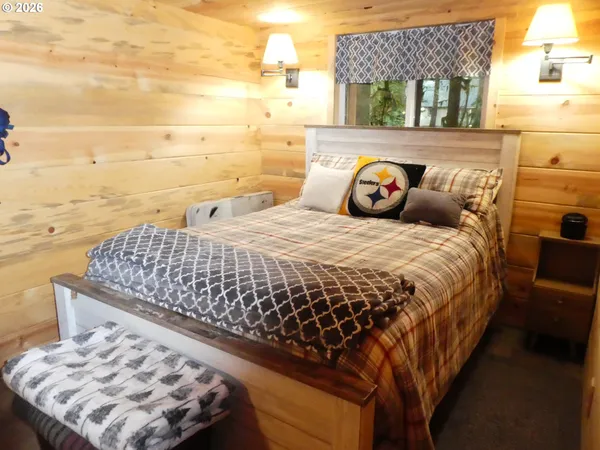 a bed sitting in a bedroom next to a lamp next to a window