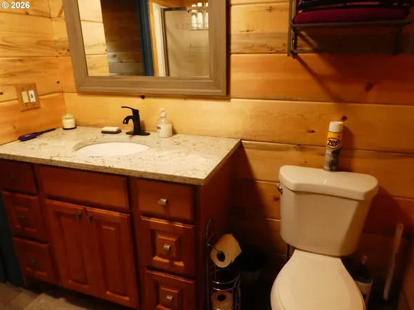 a bathroom with a granite countertop toilet sink and mirror