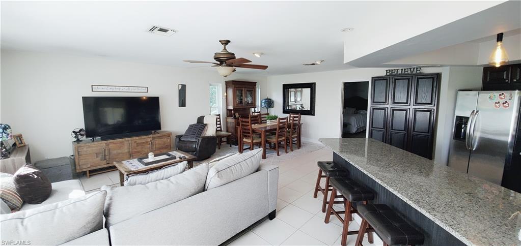 391 Torrey Pines Point Naples, FL 34113 - Photo 11 of 32 a living room with furniture and a flat screen tv