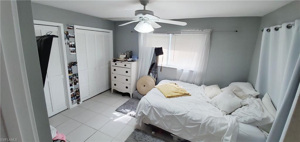 391 Torrey Pines Point Naples, FL 34113 - Photo 17 of 32 a bedroom with a bed and a chandelier