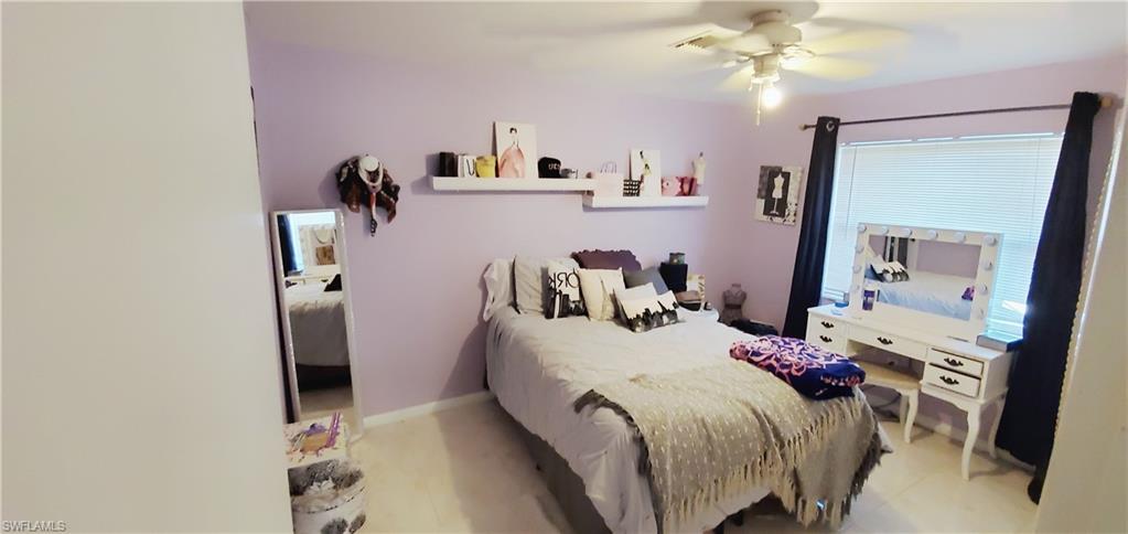 391 Torrey Pines Point Naples, FL 34113 - Photo 18 of 32 a bedroom with a bed and a chandelier