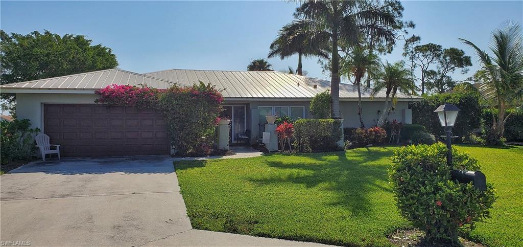 391 Torrey Pines Point Naples, FL 34113 - Photo 2 of 32 a front view of house with a garden