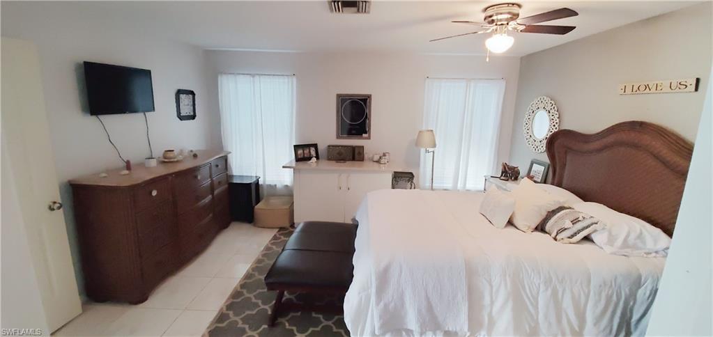 391 Torrey Pines Point Naples, FL 34113 - Photo 21 of 32 a bedroom with a bed and a flat screen tv