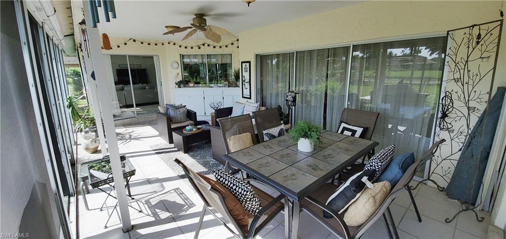391 Torrey Pines Point Naples, FL 34113 - Photo 26 of 32 a living room with couches a fireplace and a dining table with garden view