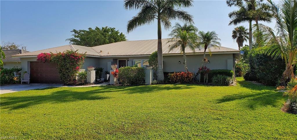 391 Torrey Pines Point Naples, FL 34113 - Photo 3 of 32 a front view of house with yard and outdoor seating