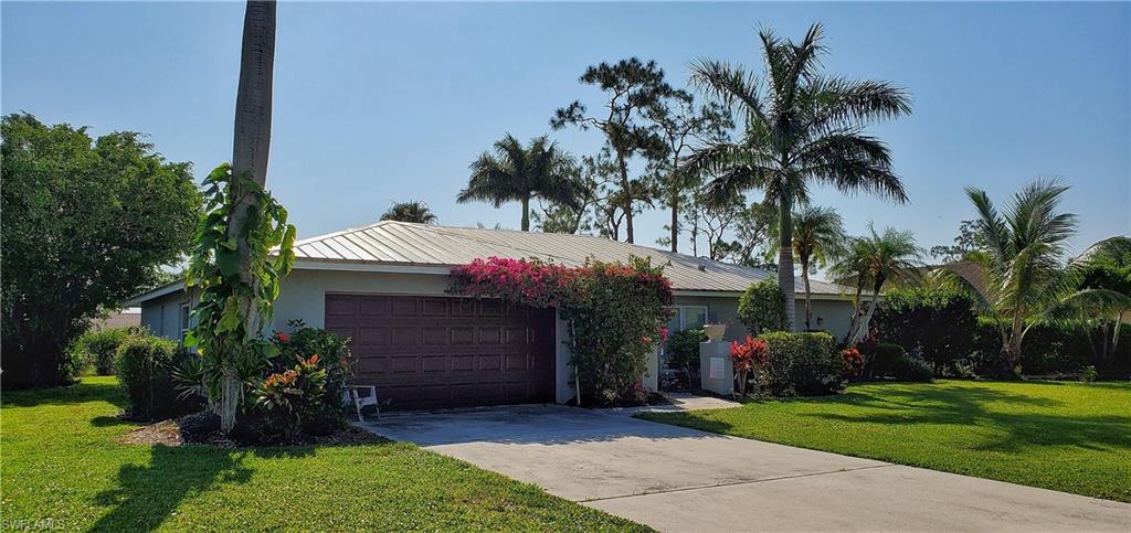 391 Torrey Pines Point Naples, FL 34113 - Photo 4 of 32 a front view of house with a garden