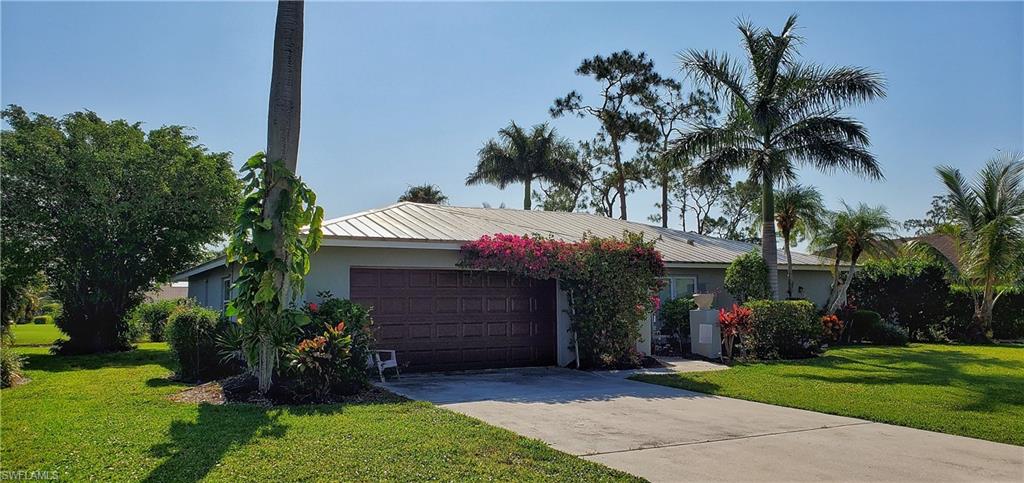 391 Torrey Pines Point Naples, FL 34113 - Photo 5 of 32 a front view of a house with a garden