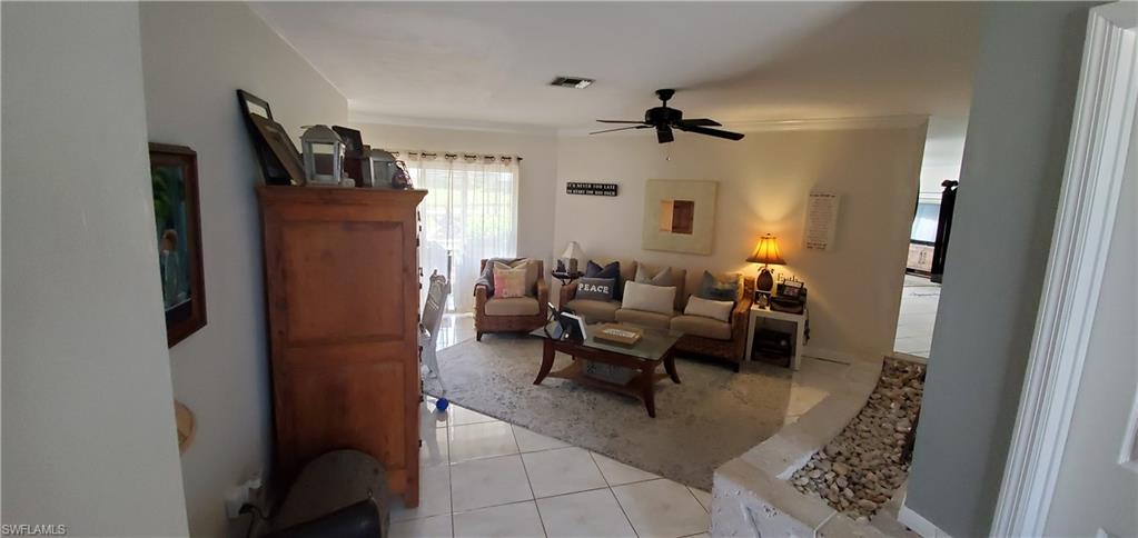 391 Torrey Pines Point Naples, FL 34113 - Photo 7 of 32 a living room with furniture a flat screen tv and a window