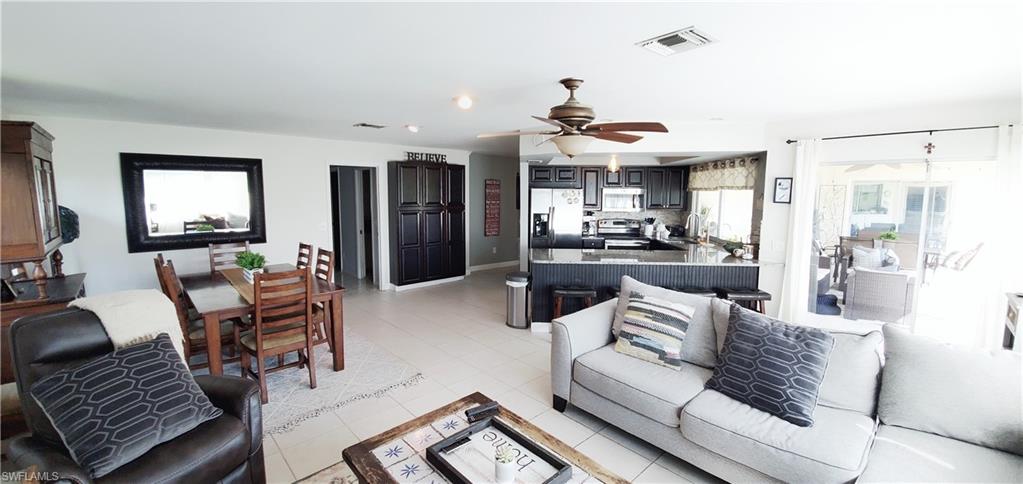 391 Torrey Pines Point Naples, FL 34113 - Photo 10 of 32 a living room with furniture and a chandelier