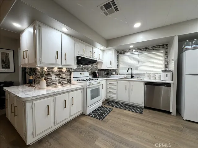 a kitchen with a sink stove cabinets and refrigerator