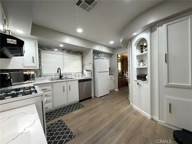 a kitchen with a refrigerator and a stove top oven
