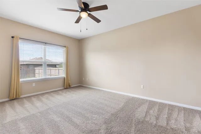 an empty room with chandelier fan