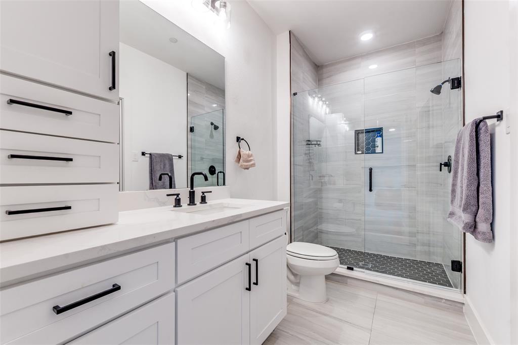 2134 Shea Road, Unit 1001 Dallas, TX 75235 - Photo 11 of 12 a bathroom with a shower sink vanity mirror and toilet