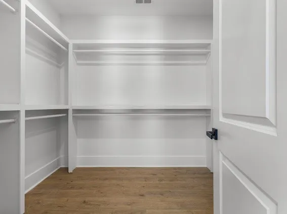 an empty room with wooden floor and bathroom