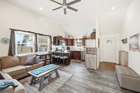 a living room with furniture kitchen view and a refrigerator