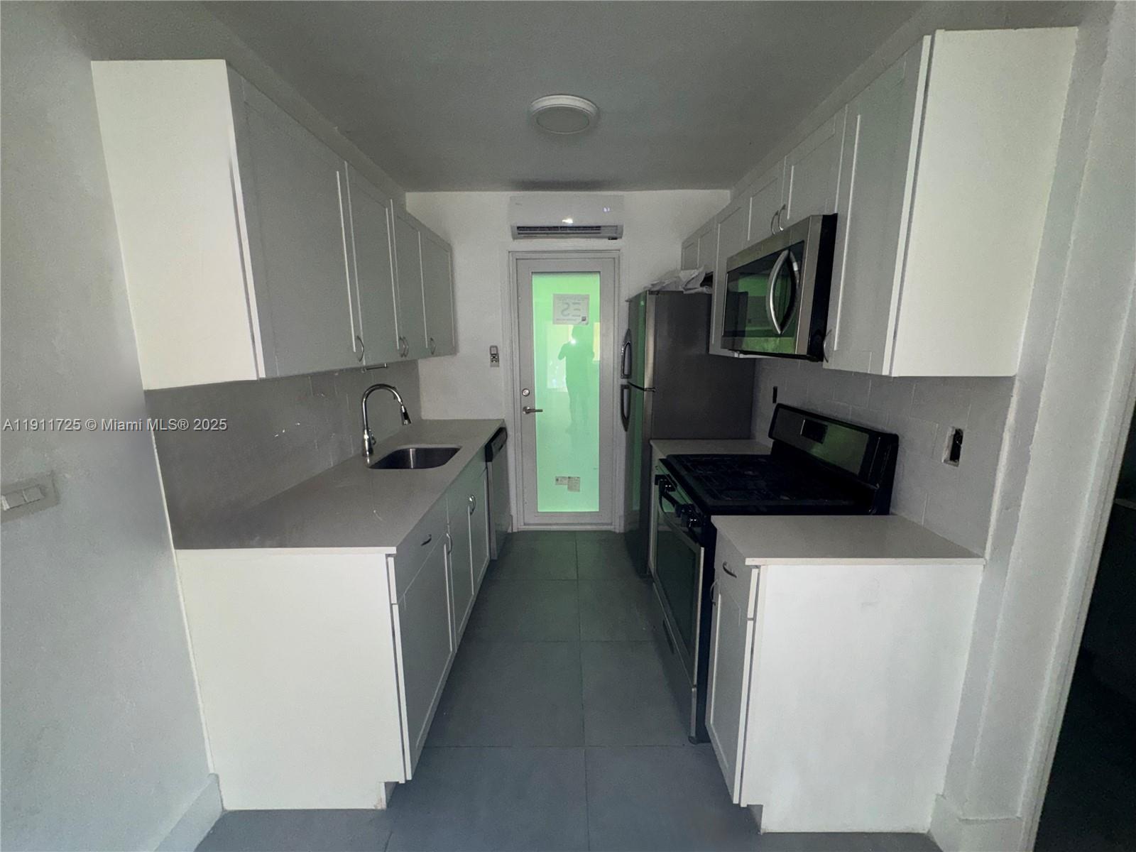75 Washington Avenue, Unit 10 Miami Beach, FL 33139 - Photo 2 of 6 a kitchen with a sink and a stove top oven