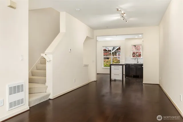 a view of a hallway with wooden floor and kitchen