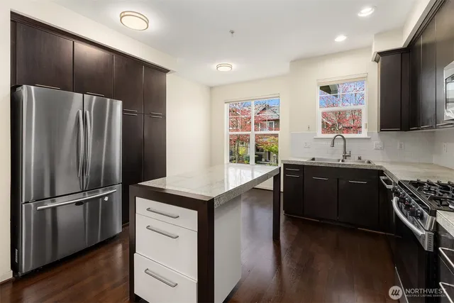 a kitchen with granite countertop a refrigerator stove and sink