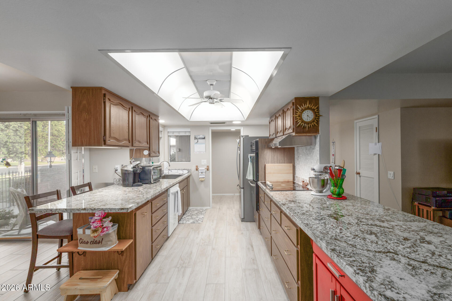 9705 West Oak Ridge Drive Sun City, AZ 85351 - Photo 4 of 23 a open kitchen with granite countertop a sink stove and cabinets