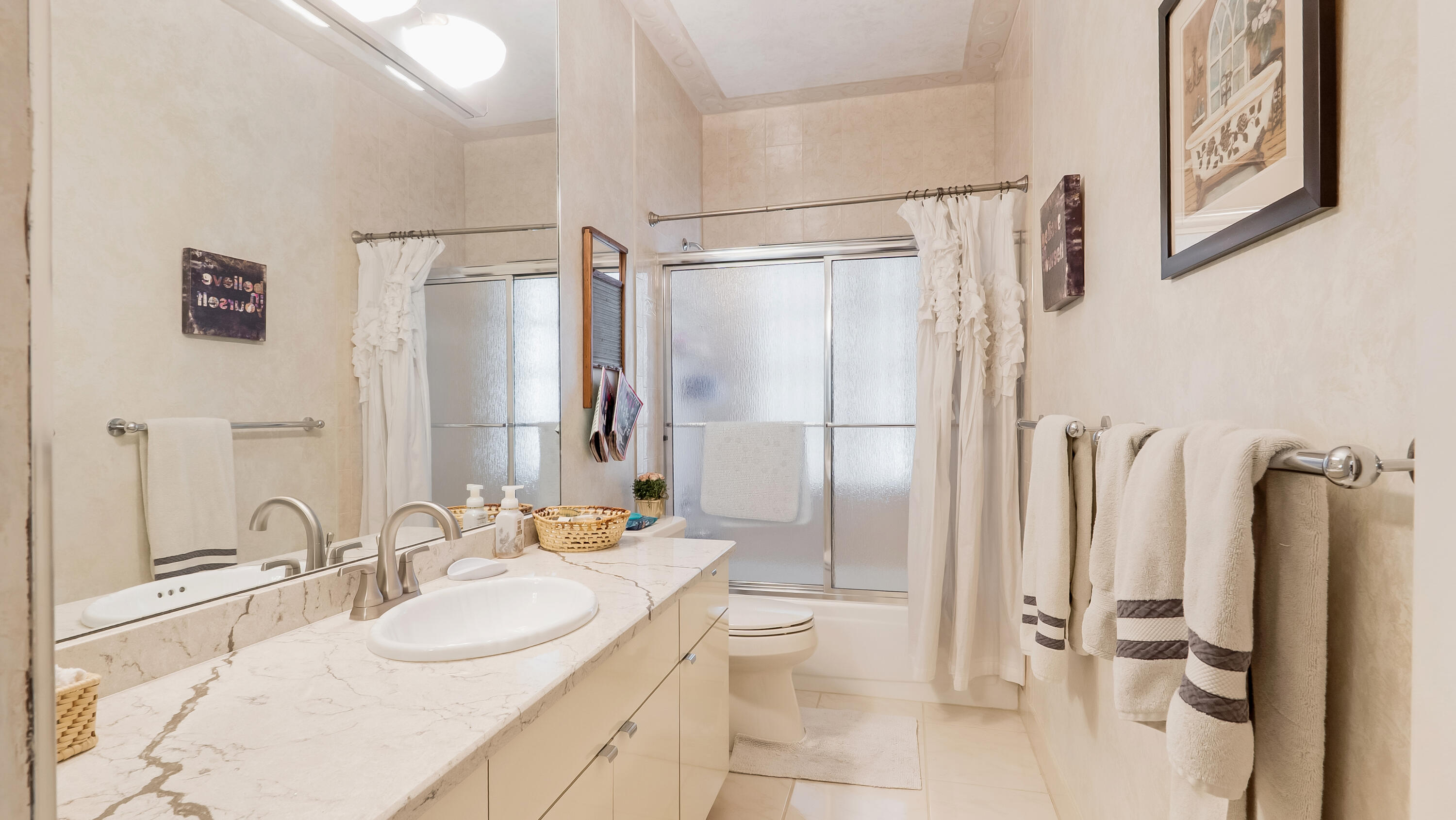 10767 Boca Woods Lane Boca Raton, FL 33428 - Photo 37 of 64 a bathroom with a double vanity sink toilet mirror and shower