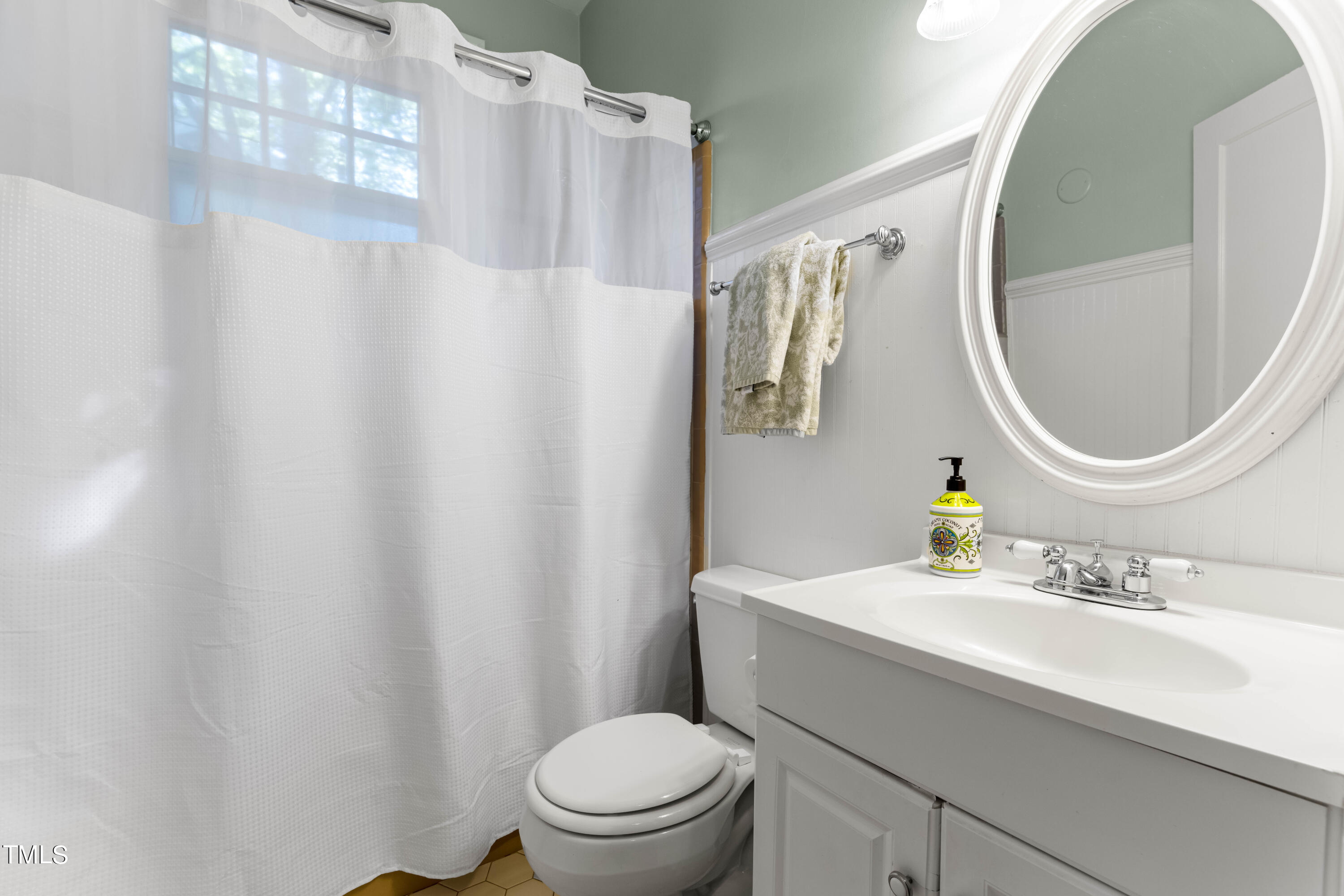 504 Holden Street Raleigh, NC 27604 - Photo 18 of 26 a bathroom with a sink a toilet and a mirror