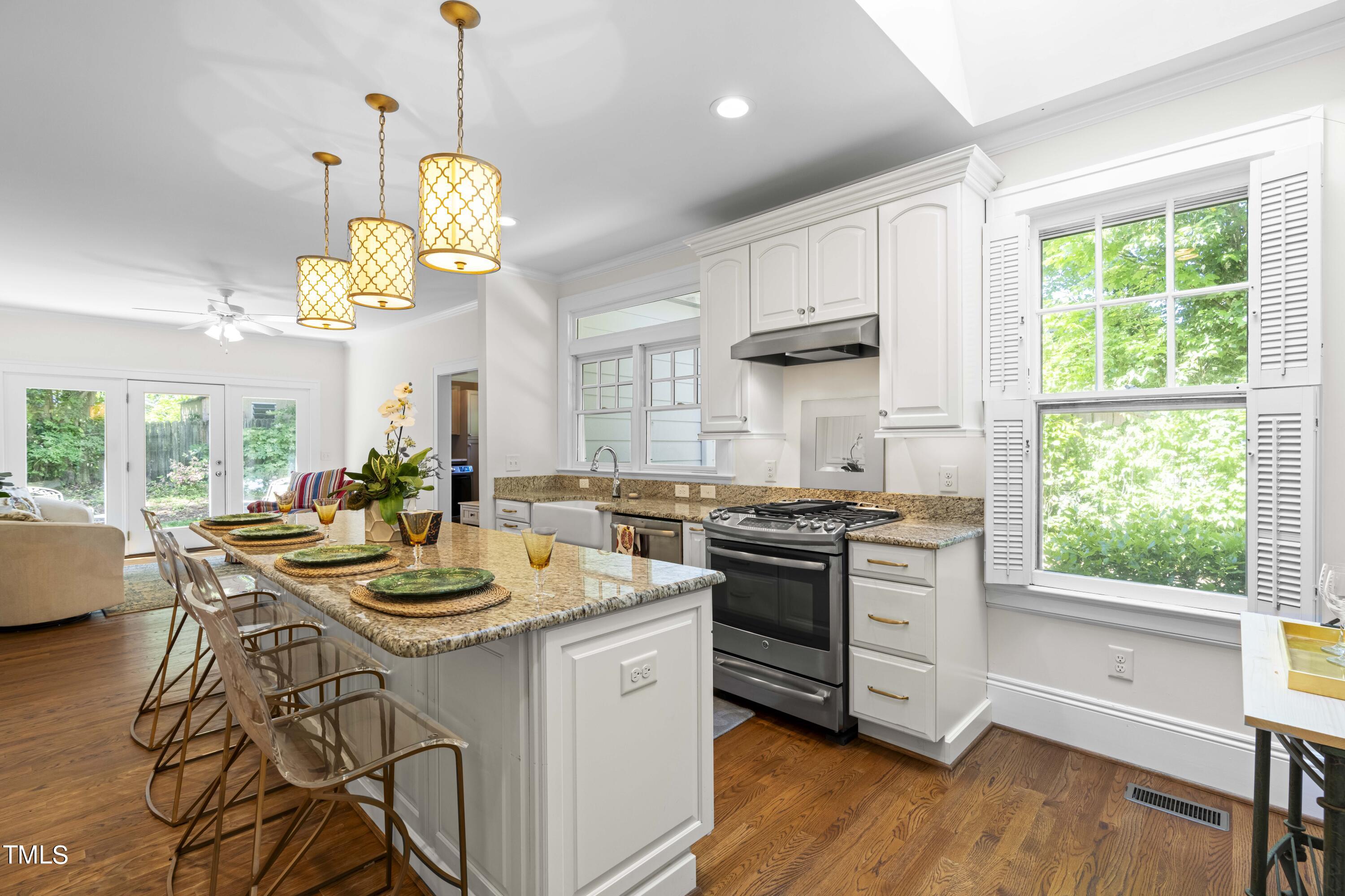 504 Holden Street Raleigh, NC 27604 - Photo 8 of 26 a kitchen with a stove a chandelier and wooden floor