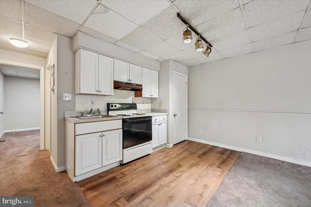 a kitchen with granite countertop a stove a sink and a refrigerator