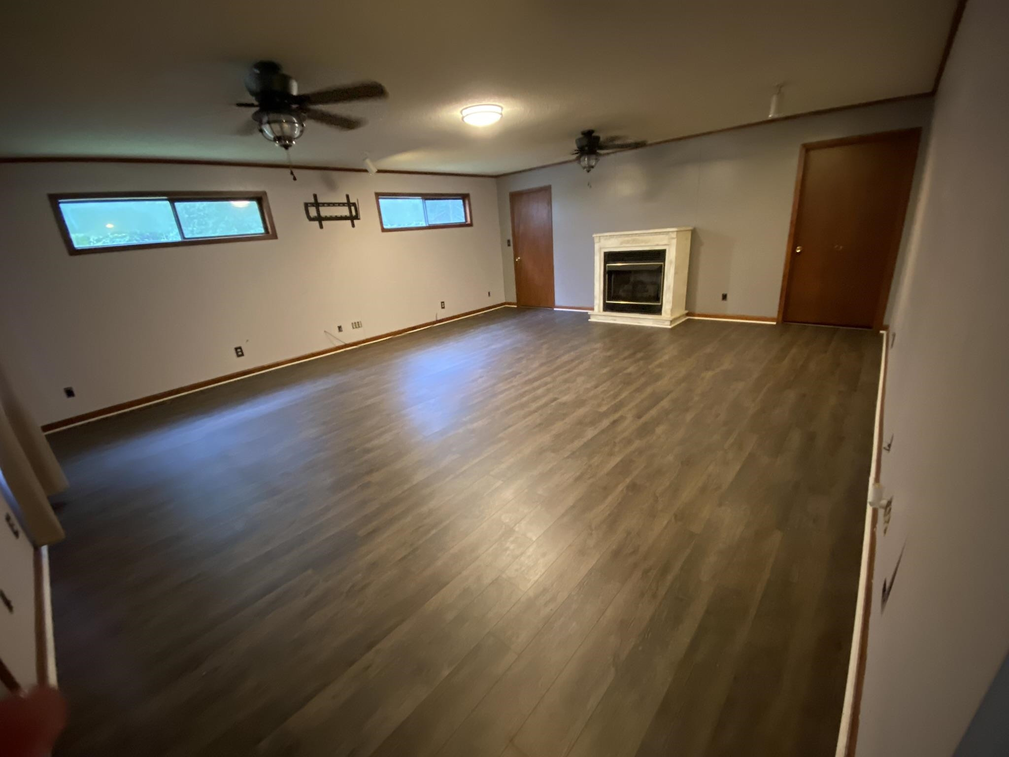 639 Beacon Road Parsons, TN 38363 - Photo 2 of 26 an empty room with wooden floor a ceiling fan and windows