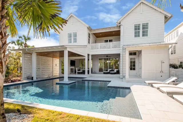 a view of a house with pool and sitting area