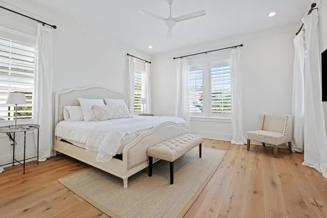 a bedroom with a bed a mirror and a large window