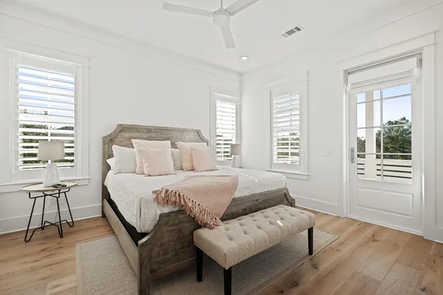 a walk in closet with wooden floor