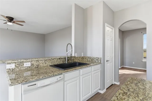a kitchen with granite countertop white cabinets and white appliances