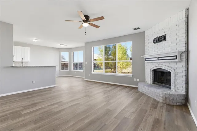 a view of a kitchen with a sink and dishwasher white cabinets with wooden floor