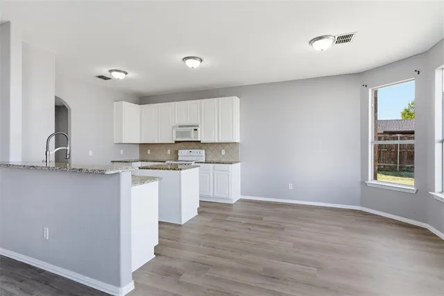 a kitchen with sink a stove and cabinets