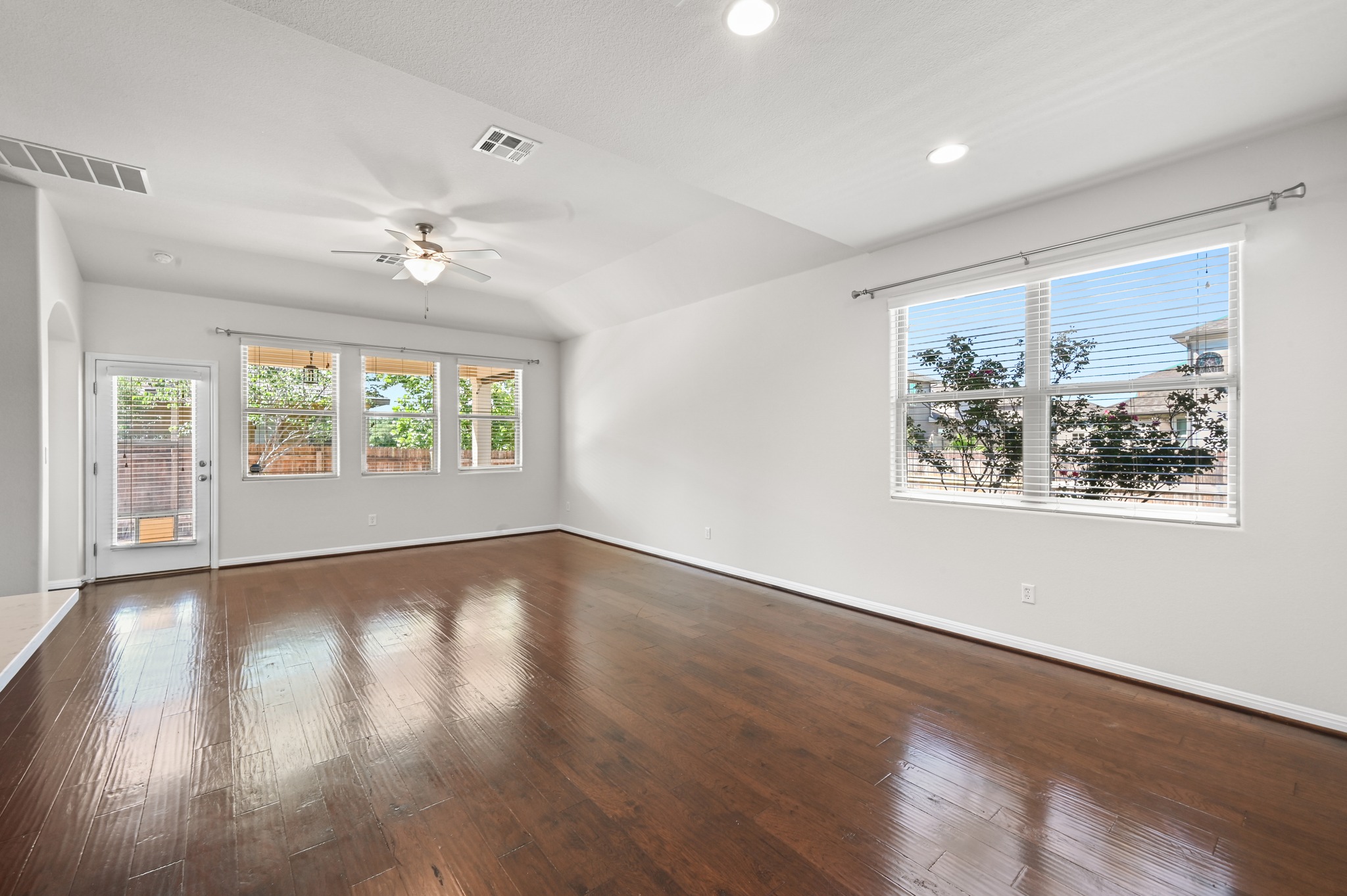 351 Wincliff Drive Buda, TX 78610 - Photo 13 of 40 Natural light floods this spacious room, highlighting its rich hardwood floors and vaulted ceilings.