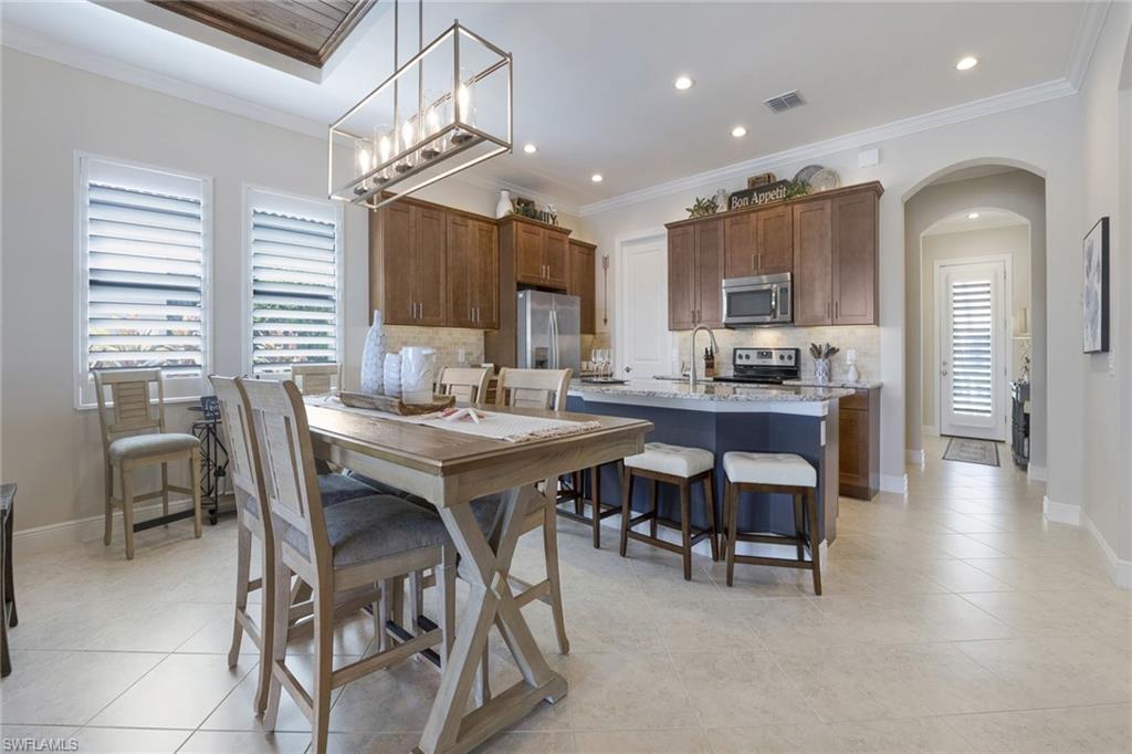 1410 Redona Way Naples, FL 34113 - Photo 12 of 50 a view of a dining room with furniture and wooden floor
