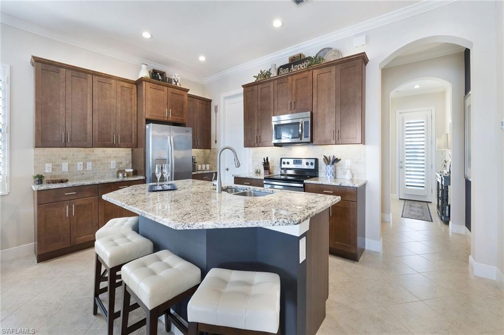 1410 Redona Way Naples, FL 34113 - Photo 13 of 50 a kitchen with granite countertop a sink cabinets and wooden floor