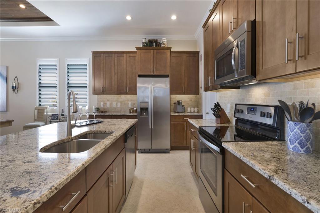 1410 Redona Way Naples, FL 34113 - Photo 14 of 50 a kitchen with stainless steel appliances granite countertop a sink a stove and a refrigerator