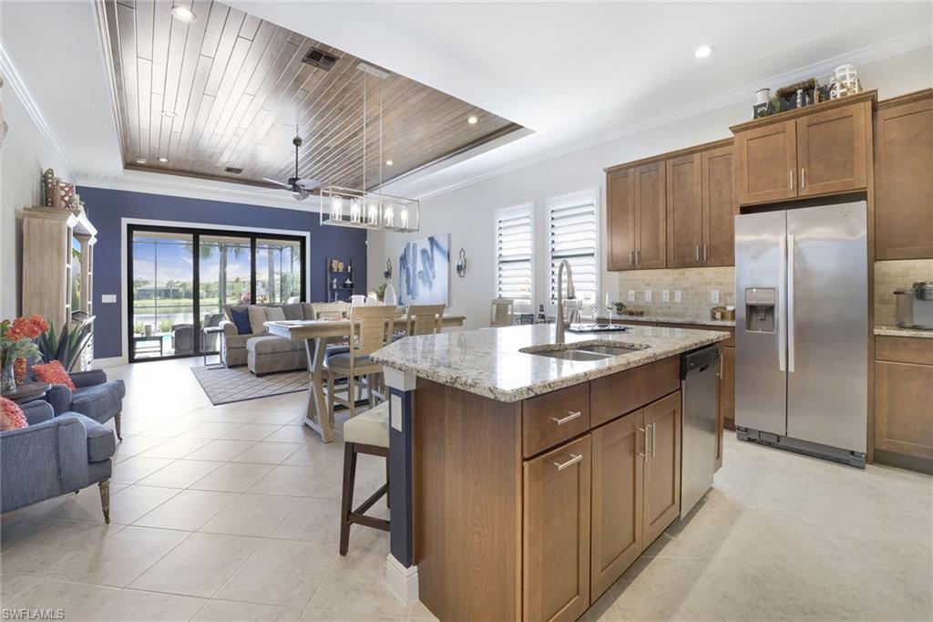 1410 Redona Way Naples, FL 34113 - Photo 17 of 50 a kitchen with kitchen island granite countertop lots of counter top space and stainless steel appliances