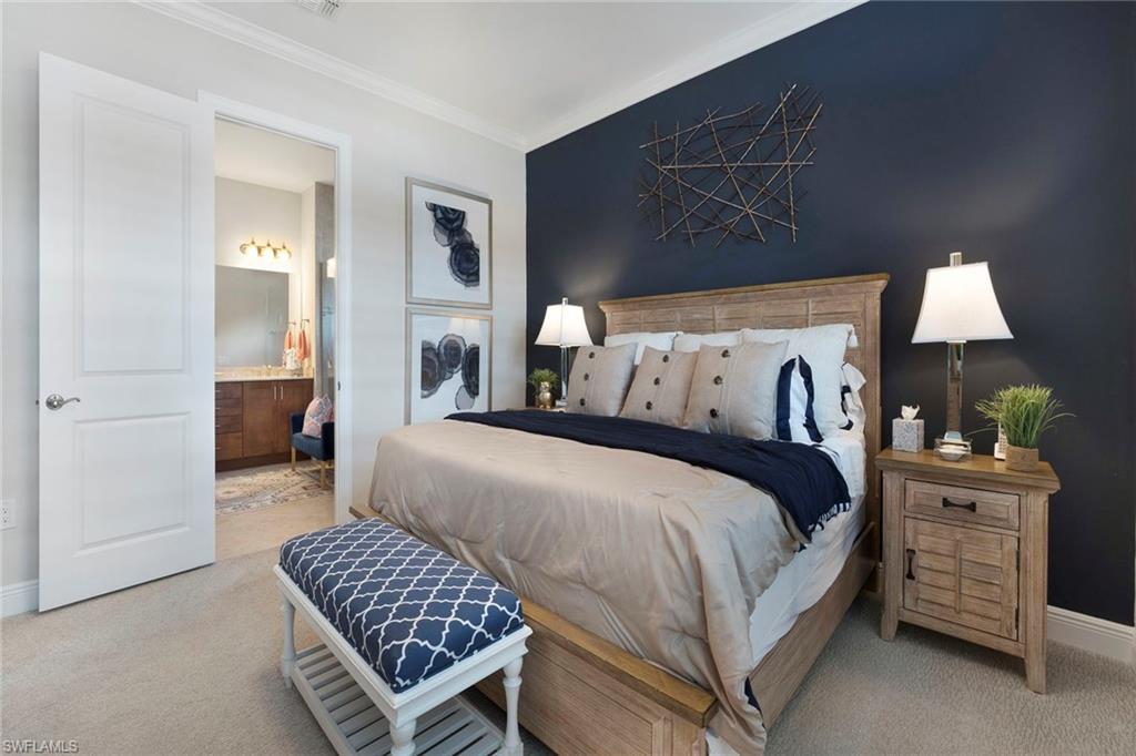 1410 Redona Way Naples, FL 34113 - Photo 21 of 50 a bedroom with a bed and dresser with mirror