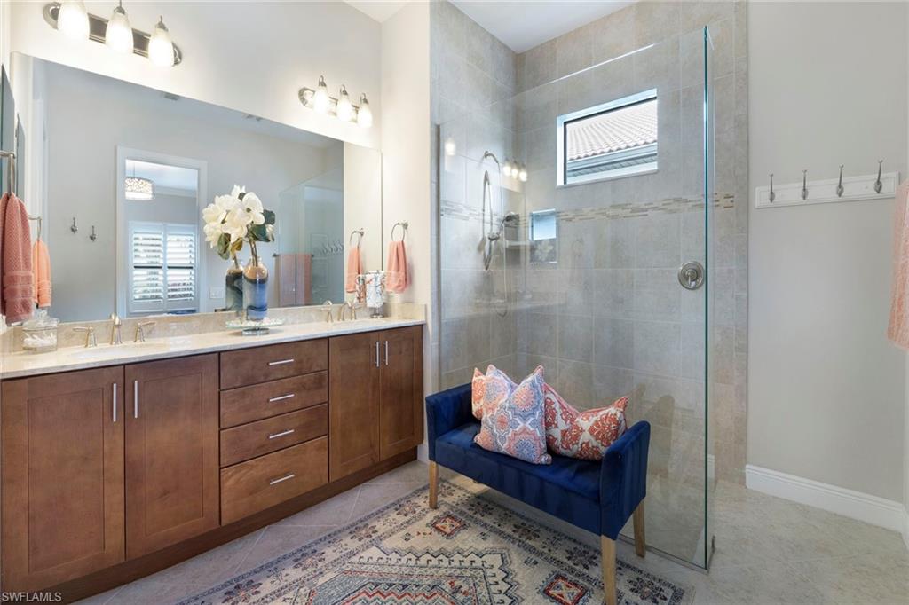1410 Redona Way Naples, FL 34113 - Photo 22 of 50 a spacious bathroom with a granite countertop tub sink and mirror