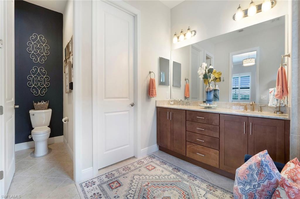 1410 Redona Way Naples, FL 34113 - Photo 23 of 50 a spacious bathroom with a sink and a mirror
