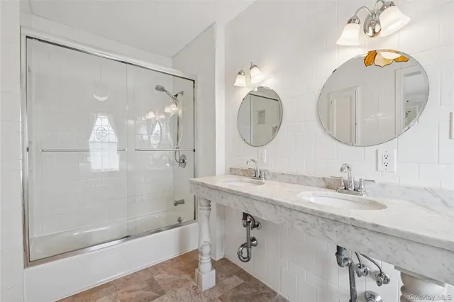 a bathroom with a sink a mirror a bathtub and shower