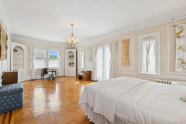 a spacious bedroom with furniture and a chandelier