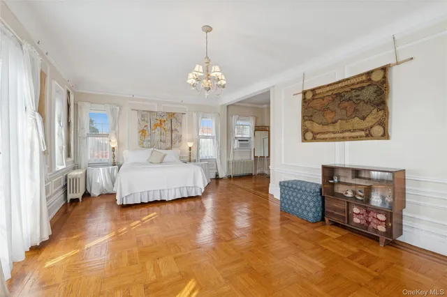 a spacious bedroom with a bed and a chandelier
