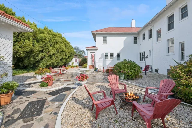 a view of a patio with couches table and chairs and potted plants