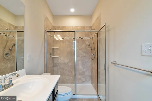 a bathroom with a sink mirror and shower